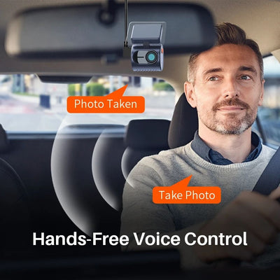 Car interior with a dashboard camera and a man sitting inside, featuring text about hands-free voice control.