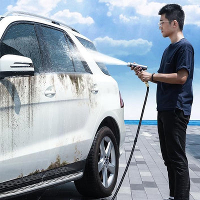 a person using the foam gun to wash his SUV car