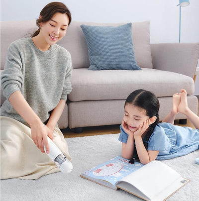 a mother and daughter using the vacuum cleaner